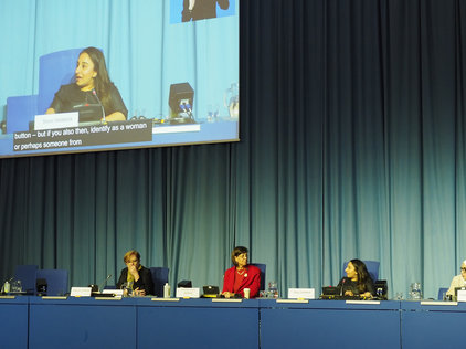 Four women sitting behind the podium at a panel session