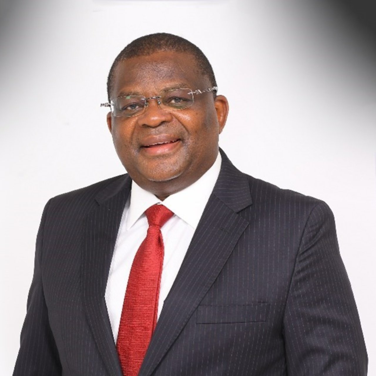 Ambassador Robinson Githae is pictured in a suit, smiling at the camera